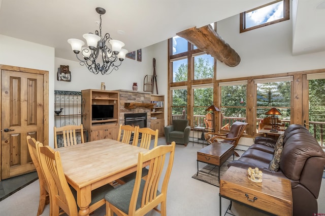 dining space featuring a stone fireplace, a notable chandelier, carpet, and a baseboard heating unit