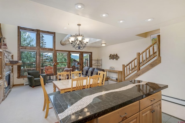 kitchen featuring tile countertops, a baseboard heating unit, a stone fireplace, and recessed lighting