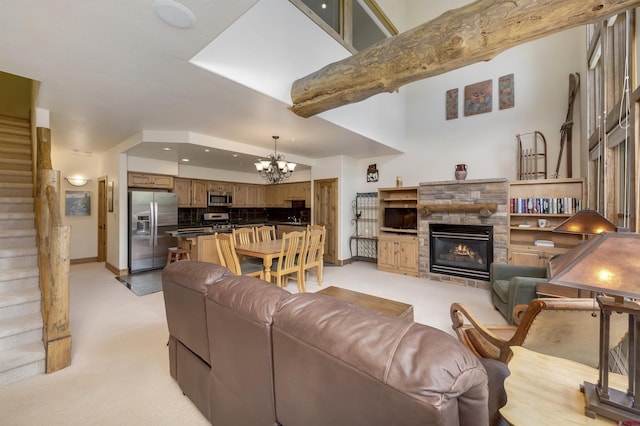 living area with baseboards, a chandelier, light colored carpet, a stone fireplace, and recessed lighting