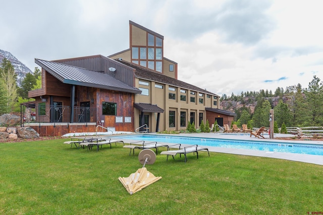 pool with a patio and a lawn