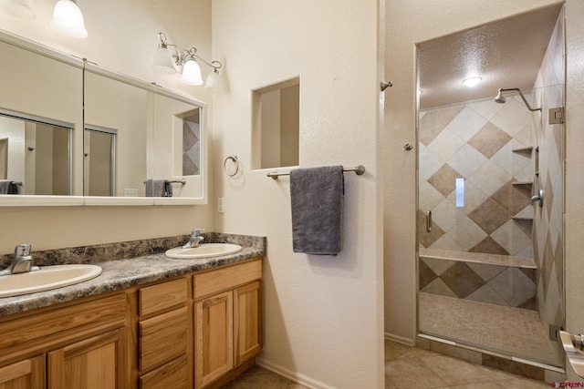 full bath featuring double vanity, a stall shower, tile patterned floors, and a sink