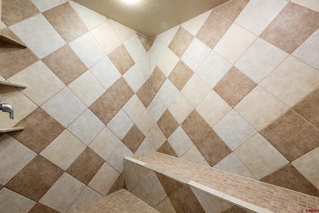 details with a tile shower and a textured ceiling