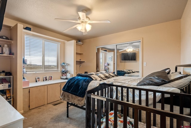 bedroom featuring visible vents, light carpet, a ceiling fan, a textured ceiling, and a closet