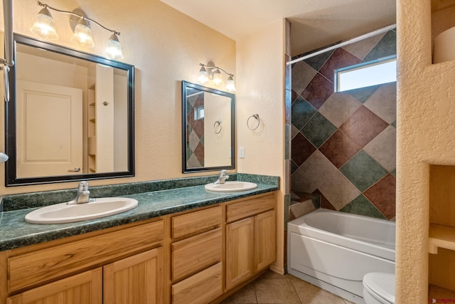 full bathroom featuring tile patterned flooring, toilet, bathing tub / shower combination, and a sink