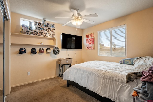 bedroom with multiple windows, baseboards, a ceiling fan, and carpet floors