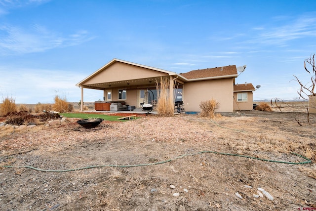 rear view of property featuring a patio and stucco siding