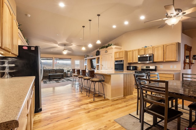 kitchen with a ceiling fan, light brown cabinets, stainless steel appliances, light countertops, and light wood-type flooring