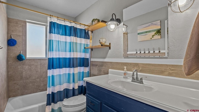 bathroom featuring a textured wall, toilet, vanity, and shower / bath combination with curtain