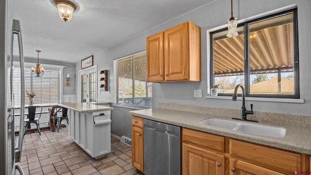 kitchen featuring visible vents, decorative light fixtures, light countertops, stainless steel appliances, and a sink