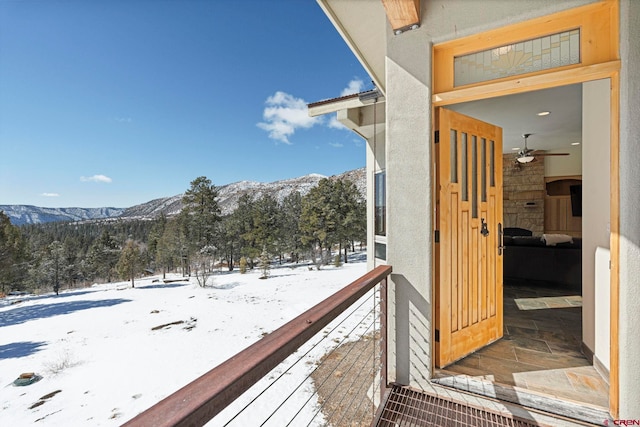 snow covered back of property with a mountain view