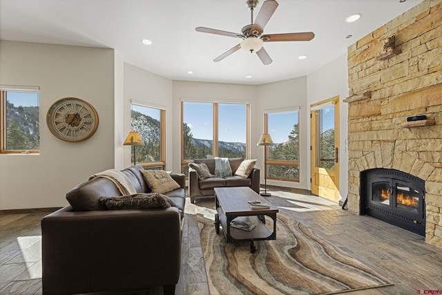 living area featuring recessed lighting, wood finished floors, a stone fireplace, and ceiling fan