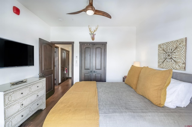 bedroom with a ceiling fan, dark wood-style flooring, and a closet