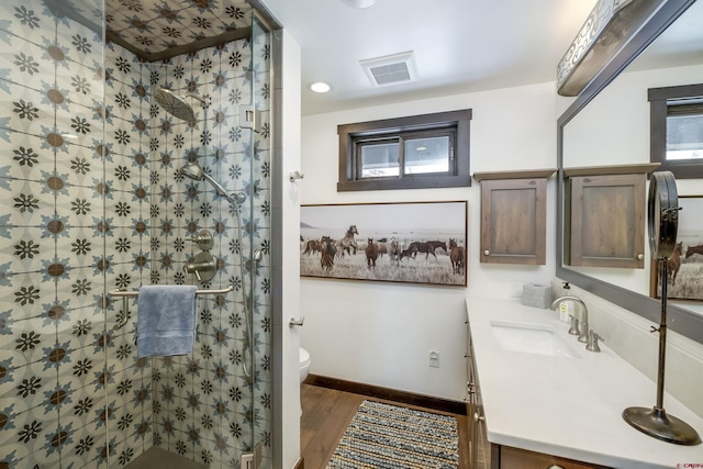 full bathroom with vanity, wood finished floors, visible vents, a stall shower, and toilet