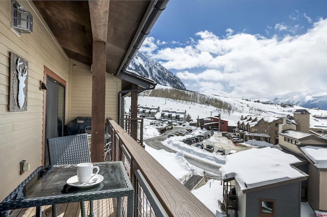 snow covered back of property featuring a mountain view