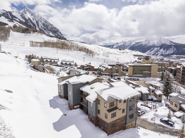 snowy aerial view with a residential view and a mountain view