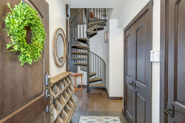 entrance foyer with stairway, baseboards, and wood finished floors