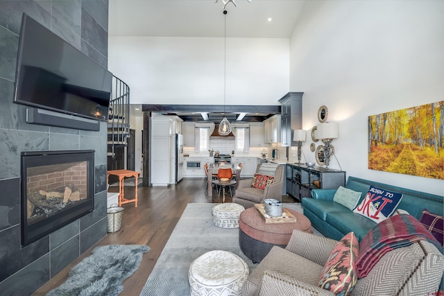 living area with a fireplace, a high ceiling, and dark wood-style floors