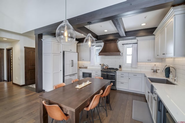 kitchen featuring a sink, dark wood finished floors, white cabinetry, built in appliances, and custom exhaust hood