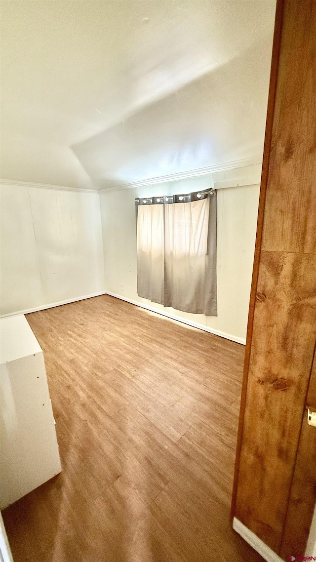 empty room featuring vaulted ceiling and wood finished floors