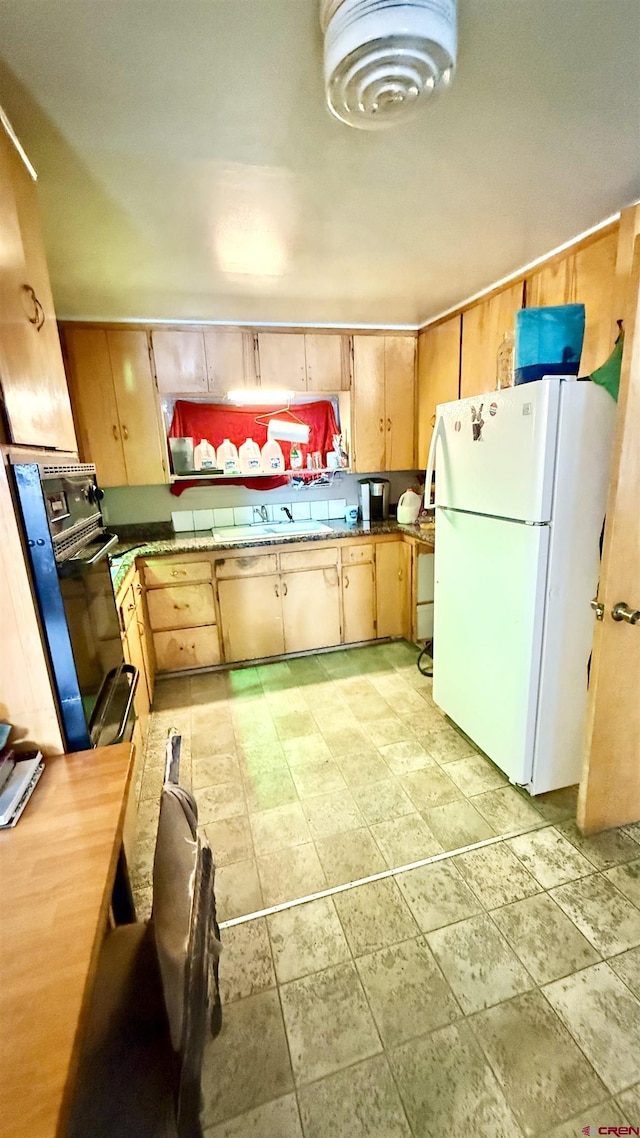 kitchen featuring freestanding refrigerator and a sink