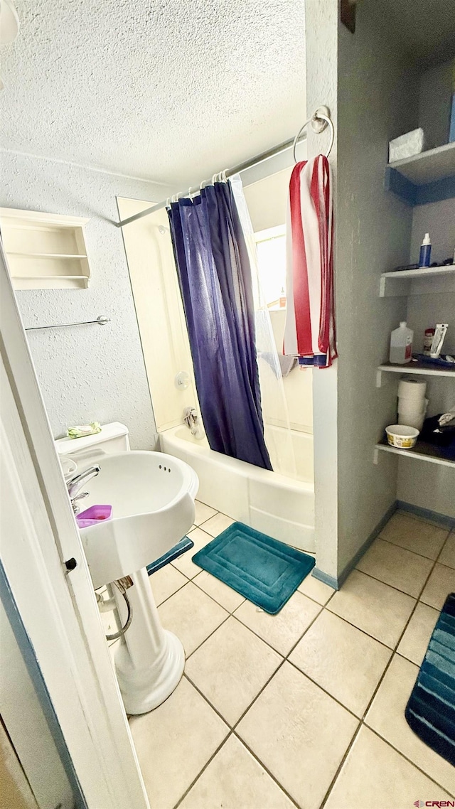 bathroom featuring tile patterned floors, shower / bathtub combination with curtain, a textured wall, and a textured ceiling