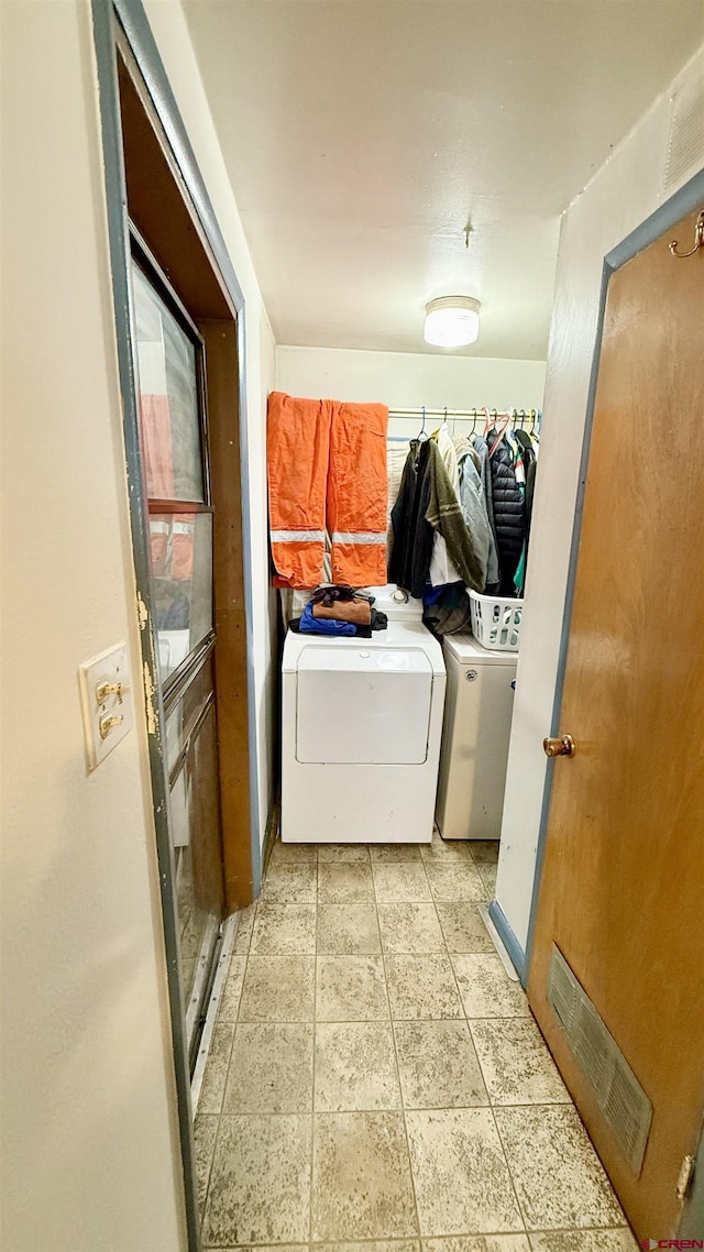 laundry area with visible vents, laundry area, and washing machine and clothes dryer