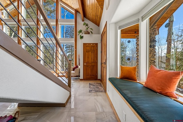 foyer with stairway, plenty of natural light, baseboards, and high vaulted ceiling