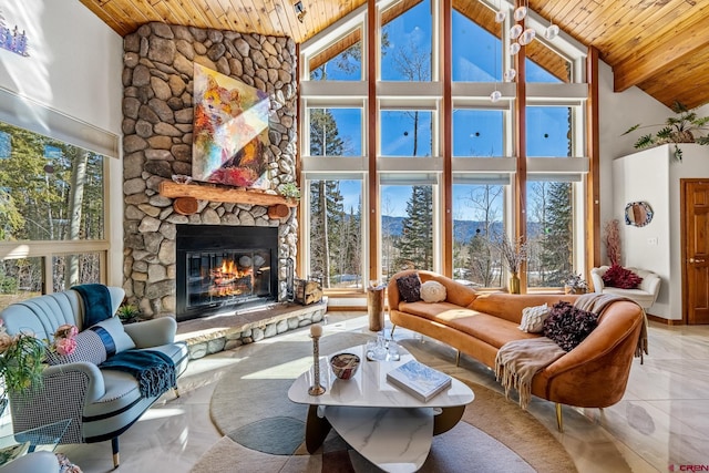 living area featuring a stone fireplace, beamed ceiling, high vaulted ceiling, and wood ceiling