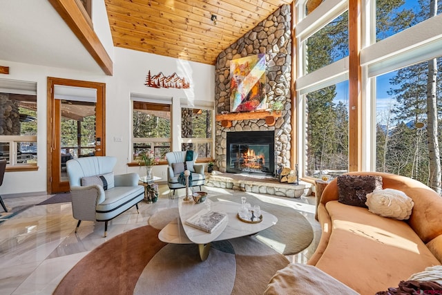 interior space featuring a stone fireplace, marble finish floor, wood ceiling, and high vaulted ceiling