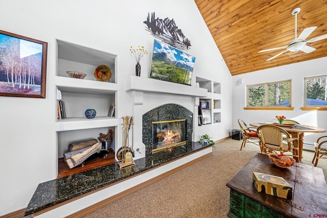 carpeted living area featuring built in features, wooden ceiling, a fireplace, baseboards, and ceiling fan