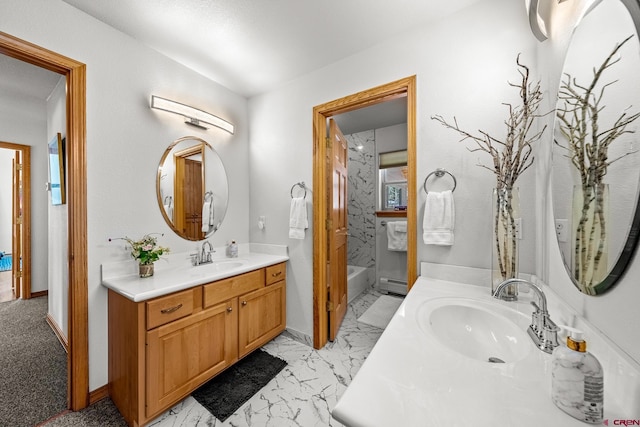 bathroom featuring two vanities, marble finish floor, a baseboard heating unit, and a sink