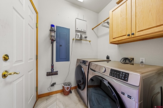 clothes washing area with electric panel, baseboards, cabinet space, and washer and dryer