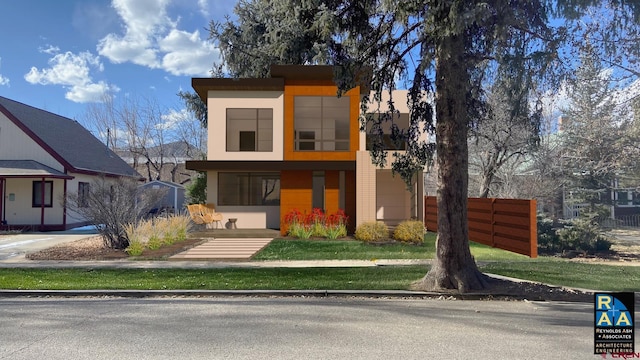 modern home featuring stucco siding and fence