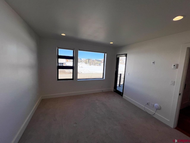 empty room featuring recessed lighting, light colored carpet, and baseboards