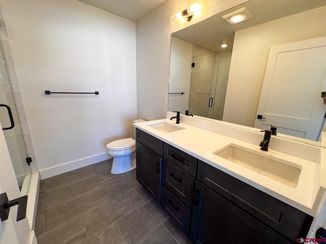 full bath featuring a sink, baseboards, toilet, and a tile shower