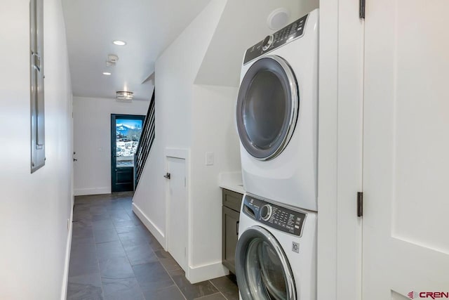 clothes washing area featuring cabinet space, recessed lighting, baseboards, and stacked washer and dryer