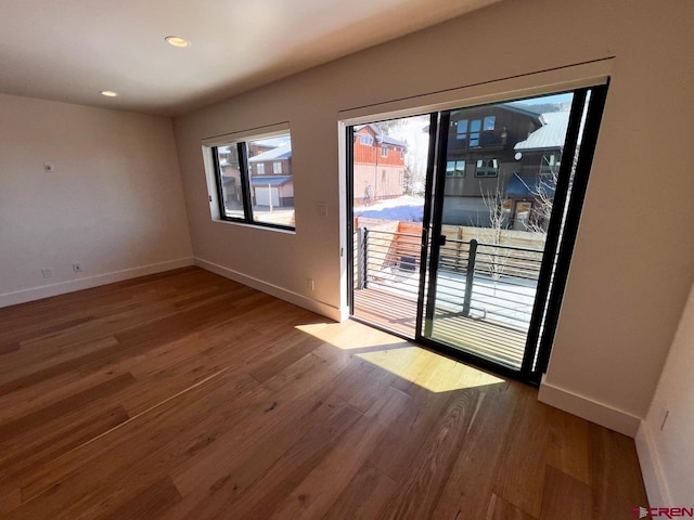 empty room featuring recessed lighting, baseboards, and wood finished floors