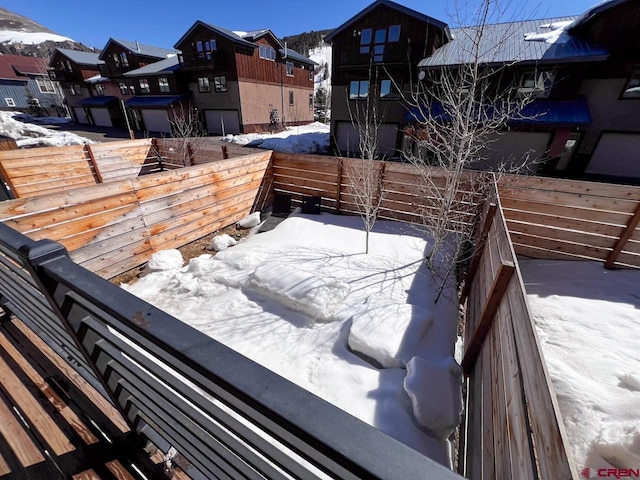 snow covered deck with a residential view