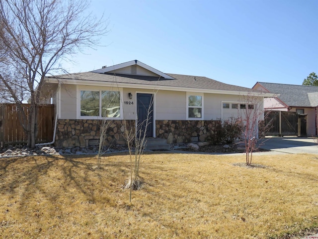 ranch-style house with fence, concrete driveway, a front yard, a garage, and stone siding