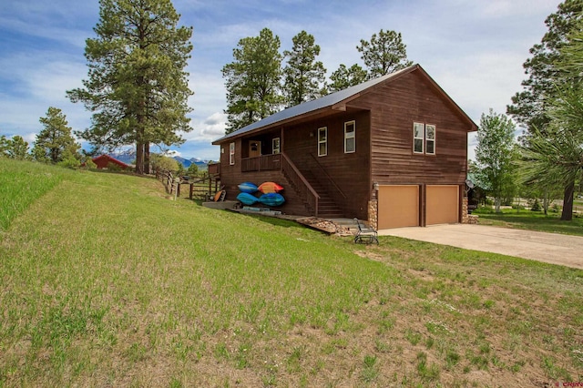 view of side of home featuring stairs, a lawn, a garage, and driveway