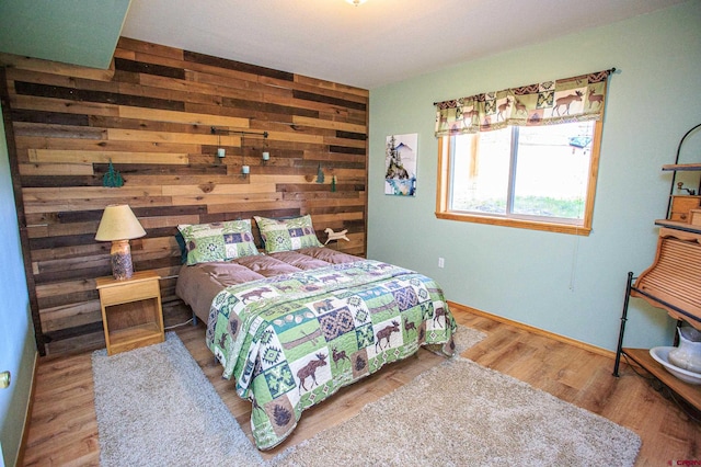 bedroom with wooden walls and wood finished floors