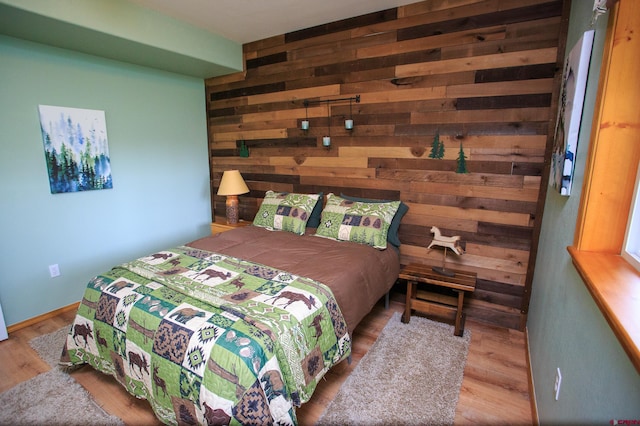 bedroom featuring wooden walls and wood finished floors