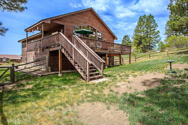 back of property with stairway, a lawn, a wooden deck, and fence