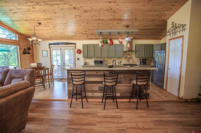 kitchen with lofted ceiling, gray cabinets, french doors, wood ceiling, and appliances with stainless steel finishes