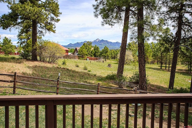 view of yard with a rural view, a mountain view, and fence