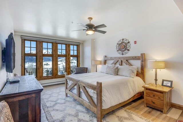 14 Hunter Hill Rd Unit C302, Mount Crested Butte, CO 81225 - bedroom featuring ceiling fan, baseboards, light wood-style floors, and a baseboard radiator