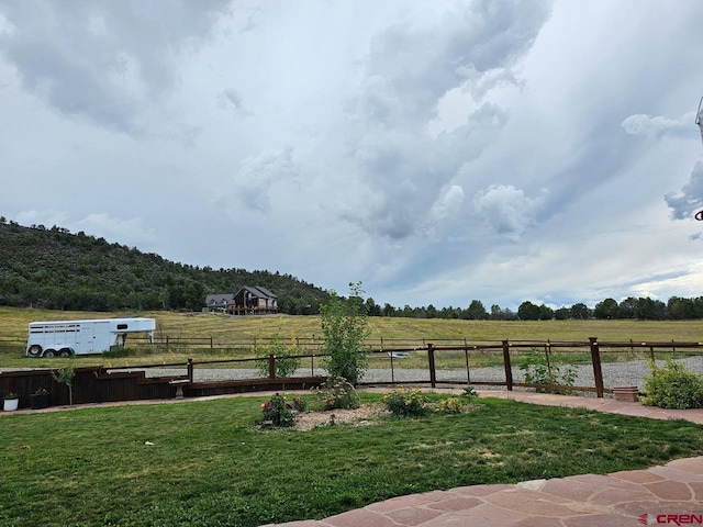 view of yard featuring a rural view and fence