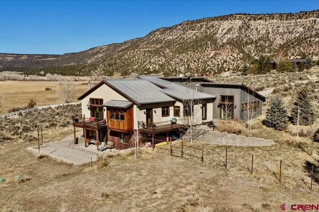 back of property with a deck with mountain view