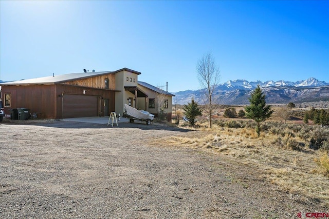 mid-century home with a mountain view, a garage, and driveway