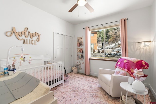 bedroom with a closet, ceiling fan, baseboards, and a nursery area